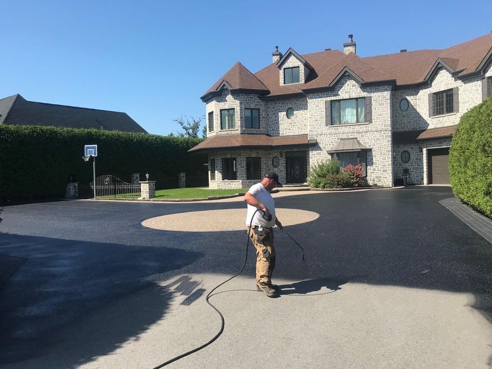 Picture of man applying sealer to asphalt